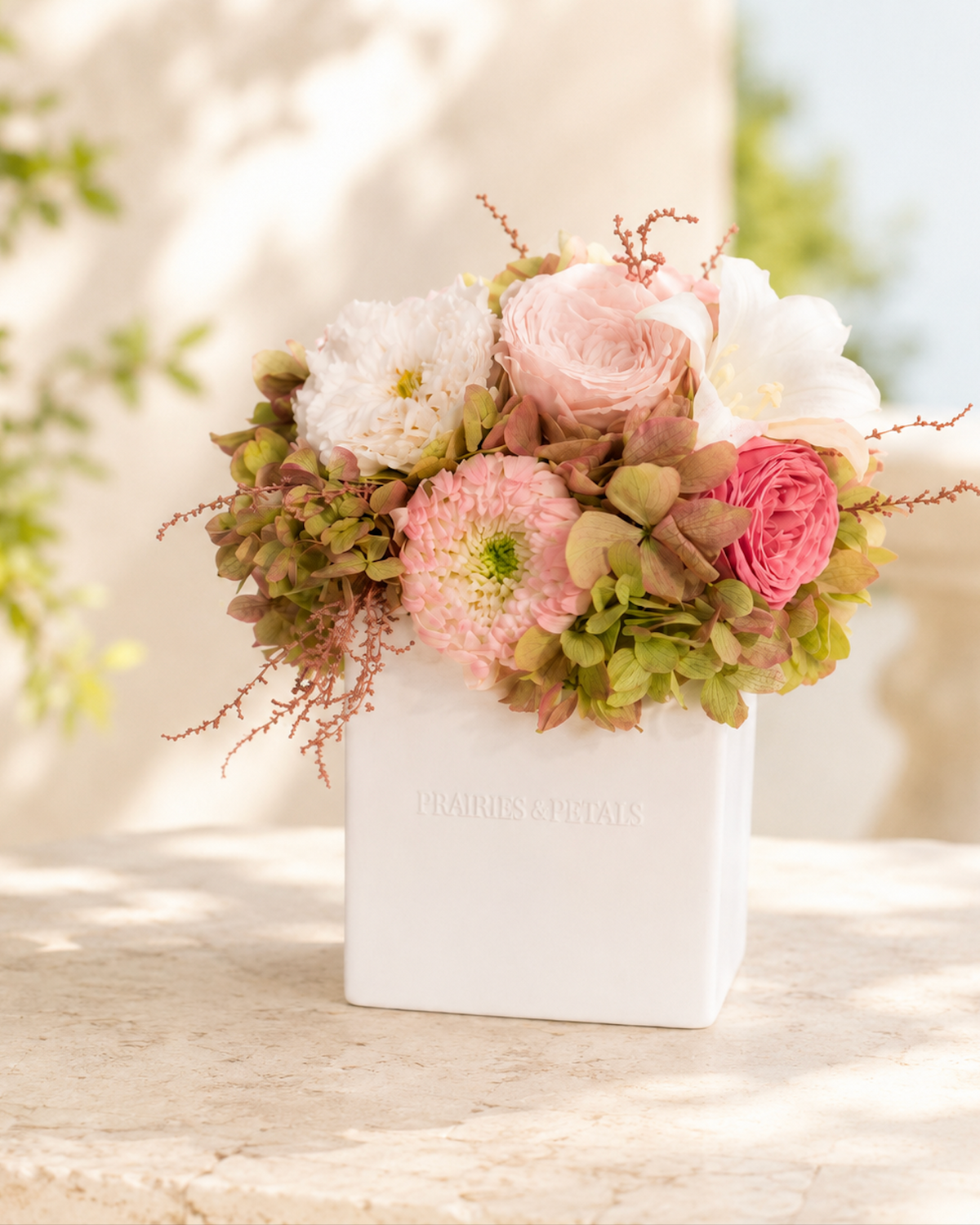 Renoir arrangement with blush garden roses and a white lily